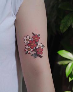 a woman's arm with flowers on it and a small bird in the middle