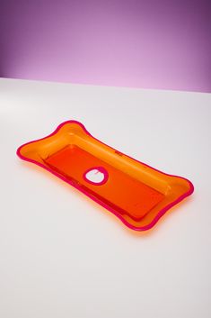 an orange and pink tray sitting on top of a white table