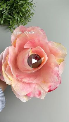 a person holding a pink flower with the words easy crafts written on it in front of them