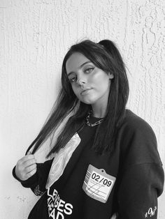 black and white photograph of a woman with her hand on her hip wearing a sweatshirt