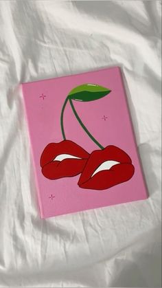 a painting of two cherries on a pink background with green leaves and red lips