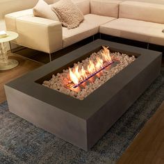 a living room with a couch and fire pit in the middle on carpeted flooring