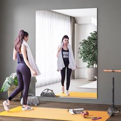 two women are doing exercises in front of a mirror