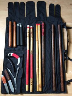 an assortment of different types of tools in a black case on a wooden table top