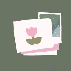 a pink flower is on top of two white papers with green leaves in the middle