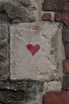 a brick wall with a red heart painted on it