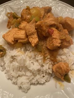 a white plate topped with rice and meat