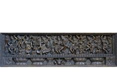 an intricately carved wooden panel with elephants and other animals in the center, against a white background