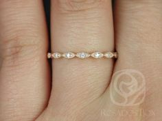 a woman's hand with a wedding band on it, and the ring has three diamonds