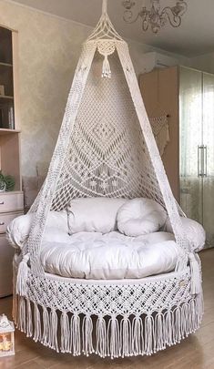 a bed with a white canopy and pillows on it in a room filled with furniture