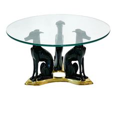 a glass table with two dogs and a chess piece on the top that is gold