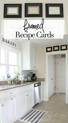 a kitchen with white cabinets and black framed recipe cards