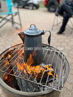 a kettle sitting on top of an open fire pit