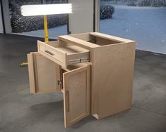 a wooden cabinet with its doors open in front of a snow covered window and street light