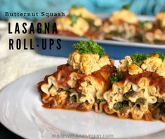 two pieces of lasagna roll ups on a white plate with broccoli