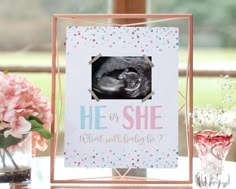 a pink and white card with a baby's photo on it next to flowers