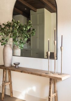 a mirror and some candles on a table