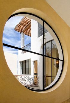 a round window in the side of a building with a balcony and balconies