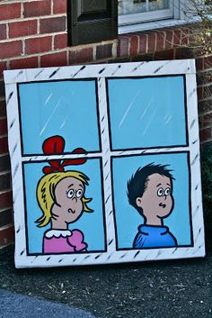 a painting on the side of a brick building depicts two people looking out a window