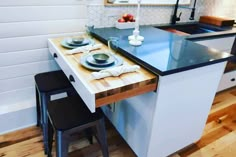 a kitchen table with two plates on it and three stools in front of it