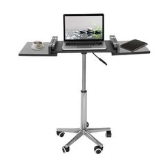 a laptop computer sitting on top of a metal table with wheels and casters,