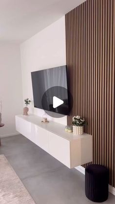 a flat screen tv sitting on top of a white entertainment center next to a wall