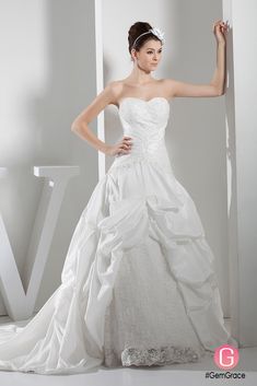 a woman in a white wedding dress posing for the camera with her hand on her hip