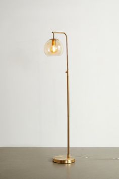 a lamp that is sitting on top of a table in front of a white wall