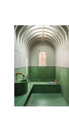 a green bathroom with two sinks and a bathtub in the middle of the room