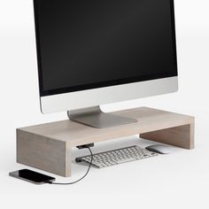 a computer monitor sitting on top of a wooden desk next to a keyboard and mouse