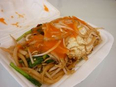 a take out box with noodles and vegetables in it