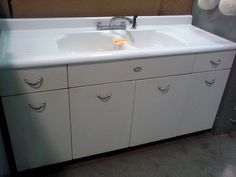 a white sink sitting under a mirror next to a wall mounted faucet in a bathroom