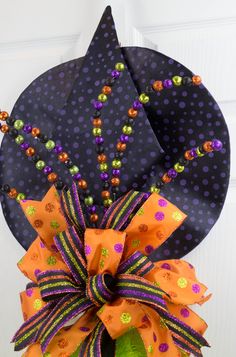 a purple and orange halloween hat with beads on the front, attached to a door