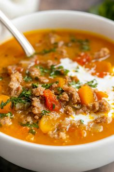 a close up of a bowl of soup with meat and vegetables