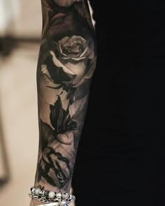 a woman's arm with black and white roses on it