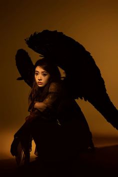 a woman sitting down with an angel wings on her head