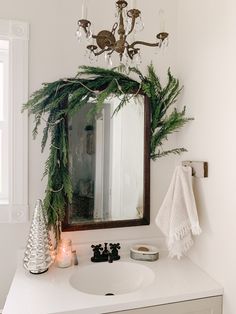 a bathroom with a mirror, sink and christmas decorations