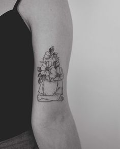 a black and white photo of a woman's arm with flowers tattooed on it