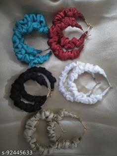 six scrunffle hair ties laid out on a bed