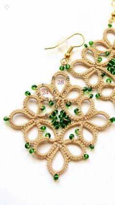 a pair of earrings with green beads