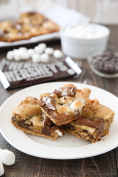 chocolate chip cookies on a plate with marshmallows and s'mores in the background