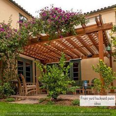 a pergolated patio covered in purple flowers and greenery next to a house