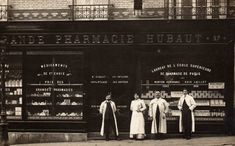 three men standing in front of a pharmacy store