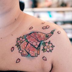 a woman's chest with an origami elephant tattoo on it