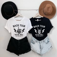 two t - shirts hanging on a wall with hats and denim shorts underneath one that says, bach tour raise hell no rights