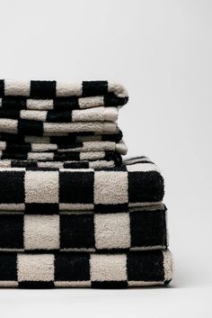 black and white towels stacked on top of each other in the shape of checkered squares