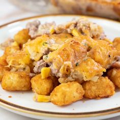 a white plate topped with tater tots covered in cheese