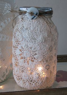 two pictures of mason jars with lace and lights in them, one has a bow on the top