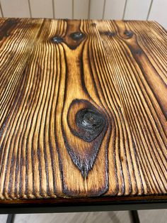 a close up of a wooden table with metal legs and wood grain pattern on it