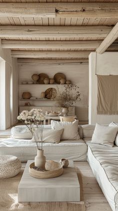 a living room filled with white furniture and lots of pillows on top of it's walls